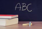 Rechtschreibung und Grammatik: Schulbücher vor einer Tafel