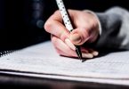 Berufsbegleitendes Studium: Schreibende Hand auf einem Notizbuch