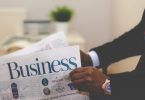 Stellensuche in Zeitungen und Zeitschriften: Mann klappt Business-Zeitung auf
